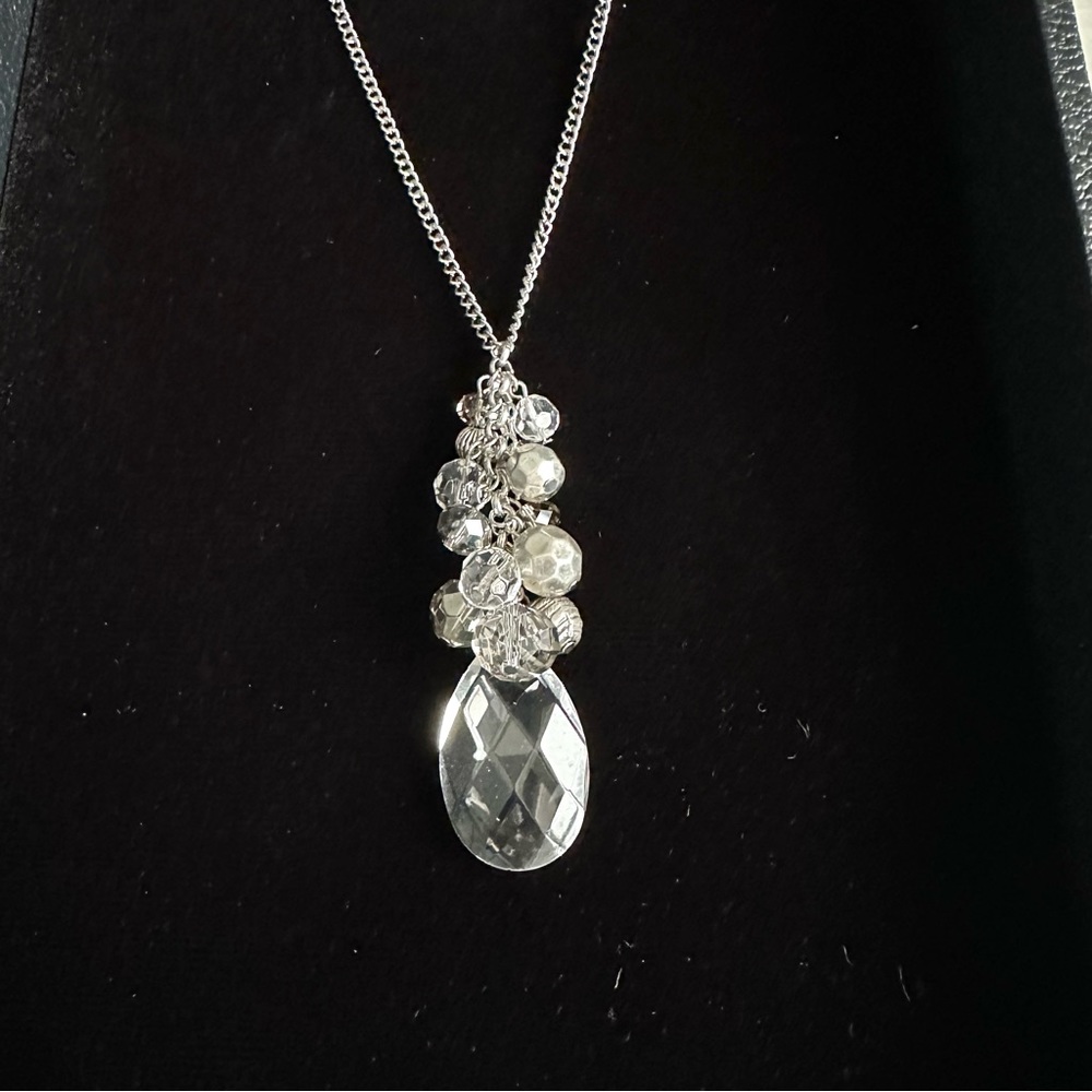 Long silver tone chain necklace with dramatic silver and clear faceted pendant.